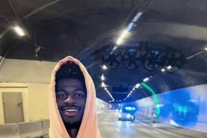 Lil Nas X poserer foran politibiler i ferd med å stoppe selskapet.