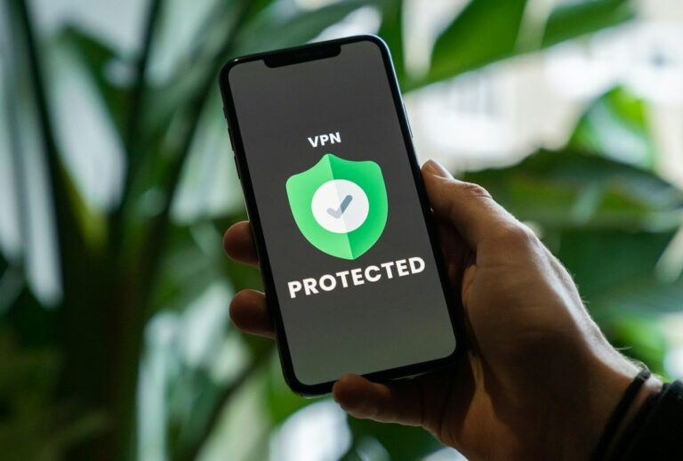 Bærbar datamaskin og mobiltelefon på et skrivebord, som illustrerer bruk av VPN for bedre personvern på nettet